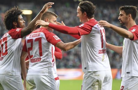 Augsburg's Caiuby, left, Alfred Finnbogason, second left, and Rani Khedira, right, celebrate the opening goal by Michael Gregoritsch, second right, during the German Bundesliga soccer match between SV Werder Bremen and FC Augsburg  in Bremen, Germany, Sunday, Oct. 29, 2017.  (Carmen Jaspersen/dpa via AP)