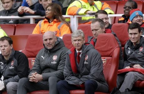 Arsenal French manager Arsene Wenger, center, sits on the bench during the English Premier League soccer match between Arsenal and Watford at the Emirates stadium in London, Sunday, March 11, 2018. (AP Photo/Matt Dunham)