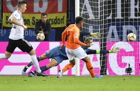 Netherlands' Donyell Malen, center, scores his side's third goal past Germany goalkeeper Manuel Neuer during the Euro 2020 group C qualifying soccer match between Germany and the Netherlands at the Volksparkstadion in Hamburg, Germany, Friday, Sept. 6, 2019. (AP Photo/Martin Meissner)