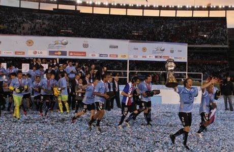 Carrying the trophy, Uruguay's Diego Lugano, right, celebrates with teammates at the end of the Copa America final soccer match against Paraguay in Buenos Aires, Argentina, Sunday, July 24, 2011. Uruguay won the Copa America for a record 15th time after beating Paraguay 3-0 with two goals scored by Diego Forlan and one by Luis Suarez. (AP Photo/Natacha Pisarenko)