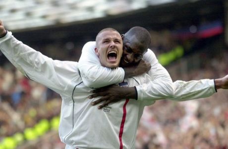 FILE - This is a Saturday, Oct. 6, 2001 file photo of England's captain David Beckham, left, as he  is congratulated by teammate Emile Heskey after scoring their second goal against Greece during their 2002 World Cup qualifying match at Old Trafford Manchester England. David Beckham is retiring from soccer after the season, ending a career in which he become a global superstar since starting his career at Manchester United. The 38-year-old Englishman recently won a league title in a fourth country with Paris Saint-Germain. He said in a statement Thursday May 16, 2013 he is "thankful to PSG for giving me the opportunity to continue but I feel now is the right time to finish my career, playing at the highest level."  (AP Photo/Adam Butler, File)