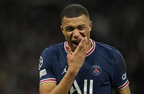 PSG's Kylian Mbappe rubs his cheek after falling on the side of his face during the Champions League, round of 16, second leg soccer match between Real Madrid and Paris Saint-Germain at the Santiago Bernabeu stadium in Madrid, Spain, Wednesday, March 9, 2022. (AP Photo/Manu Fernandez)