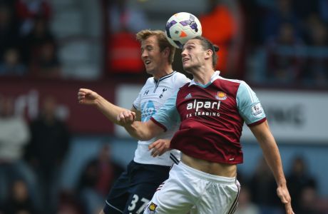 West Ham's Andy Caroll, right, heads the ball under pressure from Tottenham's Harry Kane during their English Premier League soccer match between West Ham United and Tottenham Hotspur at the Boleyn stadium in London Saturday, May  3  2014. (AP Photo/Alastair Grant)