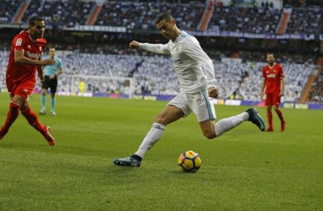 Real Madrid's Cristiano Ronaldo, right, vies for the ball with Sevilla's Gabriel Mercado during the Spanish La Liga soccer match between Real Madrid and Sevilla at the Santiago Bernabeu stadium in Madrid, Saturday, Dec. 9, 2017. Ronaldo scored twice in Real Madrid's 5-0 victory. (AP Photo/Francisco Seco)