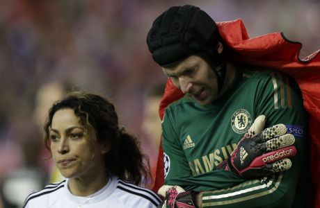 Chelsea goalkeeper Petr Cech holds his arm as he is covered by a blanket as he leaves the pitch with Chelsea team doctor Eva Carneiro following an injury during the Champions League semifinal first leg soccer match between Atletico Madrid and Chelsea at the Vicente Calderon stadium in Madrid, Spain, Tuesday, April 22, 2014 .(AP Photo/Paul White)