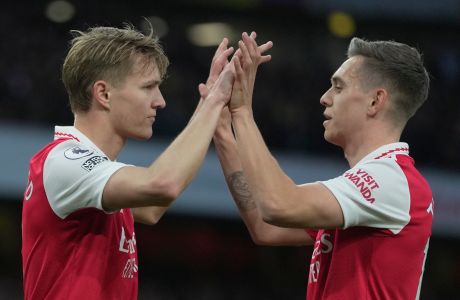 Arsenal's Martin Odegaard, left, celebrates with Arsenal's Leandro Trossard after scoring his side's opening goal during the English Premier League soccer match between Arsenal and Chelsea at the Emirates Stadium in London, Tuesday, May 2, 2023. (AP Photo/Kin Cheung)