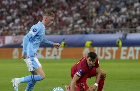 Manchester City's Cole Palmer, left, controls the ball during the UEFA Super Cup Final soccer match between Manchester City and Sevilla at Georgios Karaiskakis stadium in Piraeus port, near Athens, Greece, Wednesday, Aug. 16, 2023. (AP Photo/Thanassis Stavrakis)