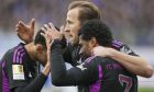 Bayern's Serge Gnabry, right, celebrates with his teammates Harry Kane, center, and Jamal Musiala after he scored his side's fourth goal during a German Bundesliga soccer match between SV Darmstadt 98 and Bayern Munich in Darmstadt, Germany, Saturday, March 16, 2024. (AP Photo/Michael Probst)