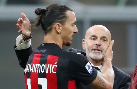 FILE - In this Saturday, Oc.t 17, 2020 file photo, AC Milan manager Stefano Pioli, right, congratulates Zlatan Ibrahimovic at the end of the Serie A soccer match between Inter Milan and AC Milan at the San Siro Stadium, in Milan, Italy. AC Milan coach Stefano Pioli has recovered from the coronavirus and will be back on the sidelines for Thursdays Europa League match against Celtic. Milan said on Wednesday that the latest tests carried out on Pioli and his assistant Giacomo Murelli were negative for COVID-19. (AP Photo/Antonio Calanni, File)