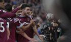 West Ham's Declan Rice is mobbed by teammates as he celebrates towards his teams fans after scoring his sides first goal during the English Premier League soccer match between Southampton and West Ham United and at St Mary's Stadium in Southampton, England, Sunday, Oct. 16, 2022. (AP Photo/Kin Cheung)
