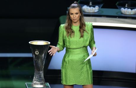 Presenter Laura Wontorra speaks next to the tournament trophy during the soccer Europa Conference League draw in Istanbul, Turkey, Friday, Aug. 27, 2021. (AP Photo/Emrah Gurel)