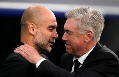 Real Madrid's head coach Carlo Ancelotti, right, greets Manchester City's head coach Pep Guardiola before the Champions League semifinal first leg soccer match between Real Madrid and Manchester City at the Santiago Bernabeu stadium in Madrid, Spain, Tuesday, May 9, 2023. (AP Photo/Manu Fernandez)