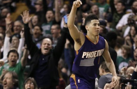 Phoenix Suns guard Devin Booker gestures after he scored a basket, as fans cheer him at TD Garden in the fourth quarter of the Suns' NBA basketball game against the Boston Celtics, Friday, March 24, 2017, in Boston. Booker scored 70 points, but the Celtics wonp 130-120. Booker is just the sixth player in NBA history to score 70 or more points in a game. (AP Photo/Elise Amendola)