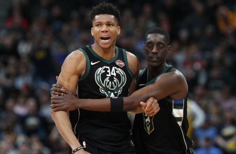 Milwaukee Bucks guard Tony Snell, right, restrains forward Giannis Antetokounmpo and guides toward the bench after Antetokounmpo was called for his sixth personal foul, in the second half of an NBA basketball game against the Denver Nuggets on Sunday, April 1, 2018, in Denver. The Nuggets won 128-125 in overtime. (AP Photo/David Zalubowski)