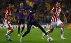 Barcelona's Ousmane Dembele, center, controls the ball past Athletic Bilbao's Mikel Vesga, right, during a Spanish La Liga soccer match between Barcelona and Athletic Club at the Camp Nou stadium in Barcelona, Spain, Sunday, Oct. 23, 2022. (AP Photo/Joan Monfort)