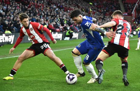 Chelsea's Enzo Fernandez, centre, challenges for the ball with Sheffield United's James McAtee, left, and Sheffield United's Ben Osborn during the English Premier League soccer match between Sheffield United and Chelsea at Bramall Lane stadium in Sheffield, England, Sunday, April 7, 2024. (AP Photo/Rui Vieira)