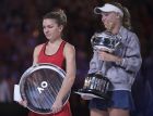 Denmark's Caroline Wozniacki, right, holds her trophy after defeating Romania's Simona Halep, left, in the women's singles final at the Australian Open tennis championships in Melbourne, Australia, Saturday, Jan. 27, 2018. (AP Photo/Andy Brownbill)
