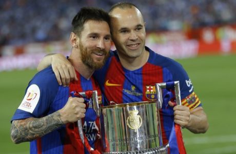 Barcelona's Lionel Messi, left and captain Andres Iniesta pose with the trophy after the Copa del Rey final soccer match between Barcelona and Alaves at the Vicente Calderon stadium in Madrid, Spain, Saturday, May 27, 2017. Barcelona won the match 3-1. (AP Photo/Francisco Seco)