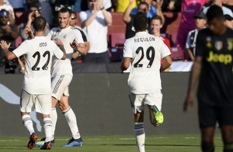 Real Madrid forward Gareth Bale, second from left, celebrates his goal with Real Madrid midfielder Isco (22) and Sergio Reguilon (29) during the first half at an International Champions Cup tournament soccer match against Juventus, Saturday, Aug. 4, 2018, in Landover, Md. (AP Photo/Nick Wass)