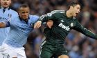 Manchester City's Vincent Kompany, left, and Real Madrid's Cristiano Ronaldo, right, battle for the ball during their Champions League Group D soccer match at the Etihad Stadium in Manchester, England, Wednesday Nov. 21, 2012. (AP Photo/Clint Hughes)  