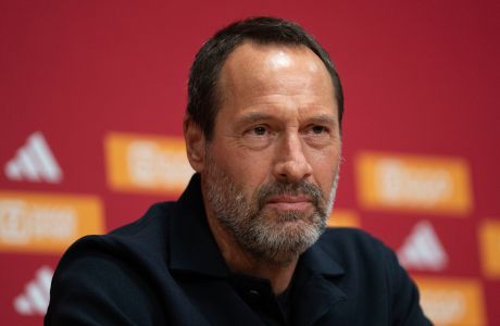 Ajax trainer John van 't Schip listens during a news conference in Amsterdam, Netherlands, Friday, Jan. 19, 2024. The lucrative Saudi soccer league lost one of its high-profile players when England midfielder Jordan Henderson quit Al-Ettifaq to sign for struggling Dutch powerhouse Ajax. (AP Photo/Peter Dejong)