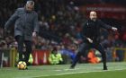 Manchester City coach Pep Guardiola, right, gestures while Manchester United coach Jose Mourinho stops a stray ball during the English Premier League soccer match between Manchester United and Manchester City at Old Trafford Stadium in Manchester, England, Sunday, Dec. 10, 2017. (AP Photo/Dave Thompson)