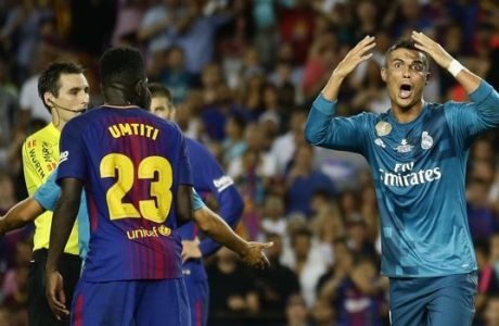 Real Madrid's Cristiano Ronaldo, right, reacts after Referee Ricardo de Burgos, left, shows a second yellow card during the Spanish Supercup, first leg, soccer match between FC Barcelona and Real Madrid at the Camp Nou stadium in Barcelona, Spain, Sunday, Aug. 13, 2017. Cristiano Ronaldo was banned for five games on Monday after shoving a referee following his red card for diving in Real Madrid's 3-1 win over Barcelona in the season-opening Spanish Super Cup. (AP Photo/Manu Fernandez)