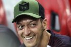 Arsenal's Mesut Ozil smiles on the bench during the International Champions Cup match between Arsenal and Atletico Madrid in Singapore, Thursday, July 26, 2018. (AP Photo/Yong Teck Lim)