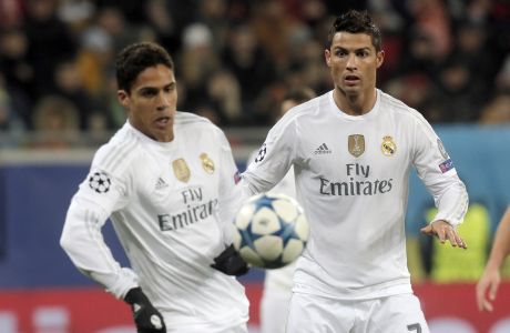Real Madrid's Raphael Varane, left, tries to control the ball while Real Madrid's Cristiano Ronaldo looks on during the Champions League Group A soccer match between FC Shakhtar and Real Madrid at Arena Lviv stadium in Lviv, Western Ukraine, Wednesday, Nov. 25, 2015. (AP Photo/Efrem Lukatsky)