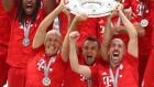 Από αριστερά, οι Άριεν Ρόμπεν, Ραφίνια και Φρανκ Ριμπερί της Μπάγερν Μονάχου σηκώνουν το τρόπαιο του πρωταθλητή μετά από τον αγώνα με την Άιντραχτ Φρανκφούρτης για την Bundesliga 2018-2019 στην 'Άλιαντς Αρένα' του Μονάχου, Σάββατο 18 Μαΐου 2019