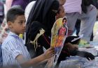 A boy buys a Ramadan decoration depicting the Egyptian Liverpool soccer player Mohamed Salah in Sayyeda Zeinab market in preparation for the holy month of Ramadan, in Cairo, Egypt, Wednesday, May 16, 2018. Muslims throughout the world are preparing to celebrate Ramadan, the holiest month in the Islamic calendar, refraining from eating, drinking, smoking and sex from sunrise to sunset. Arabic refeing to Salah reads, "Ramadan is better with Abu Mecca." (AP Photo/Amr Nabil)