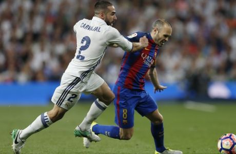 Barcelona's Andres Iniesta, right, challenges for the ball with Real Madrid's Daniel Carvajal during a Spanish La Liga soccer match between Real Madrid and Barcelona, dubbed 'el clasico', at the Santiago Bernabeu stadium in Madrid, Spain, Sunday, April 23, 2017. (AP Photo/Francisco Seco)