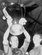 Manchester United captain Bobby Charlton holds aloft the European Cup watched by goalkeeper Alex Stepney, after United defeated Benfica 4-1 in the European Cup Final, at Wembley Stadium, England, May 29, 1968. (AP Photo/Pool)