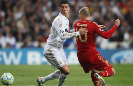 MADRID, SPAIN - APRIL 25: Arjen Robben of Bayern (R) challenges Cristiano Ronaldo of Real Madrid (L) during the UEFA Champions League semi final second leg match between Real Madrid and Bayern Muenchen at Bernabeu Stadium on April 25, 2012 in Madrid, Spain. (Photo by Christof Koepsel/Bongarts/Getty Images)