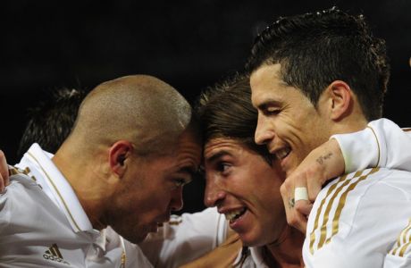 Real Madrid's Portuguese forward Cristiano Ronaldo (R) celebrates with Real Madrid's Portuguese defender Pepe (L) and Real Madrid's defender Sergio Ramos (C) after scoring during the Spanish League "El clasico" football match Barcelona vs Real Madrid at the Camp Nou stadium in Barcelona on April 21, 2012.  AFP PHOTO/JAVIER SORIANO (Photo credit should read JAVIER SORIANO/AFP/Getty Images)