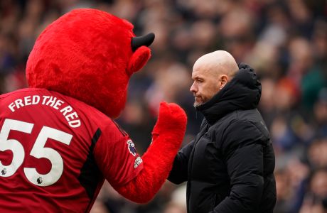 Manchester United's head coach Erik ten Hag walks past the mascot before an English Premier League soccer match between Manchester United and Everton at the Old Trafford stadium in Manchester, England, Saturday, March 9, 2024. (AP Photo/Dave Thompson)