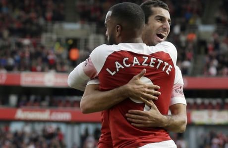 Arsenal's Alexandre Lacazette celebrates with Arsenal's Lucas Torreira his side's second goal with his teammates after his shot deflected by West Ham's Issa Diop scoring own goal during the English Premier League soccer match between Arsenal and West Ham United at the Emirates Stadium in London, Saturday Aug. 25, 2018. (AP Photo/Tim Ireland)