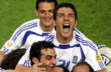 epa000220227 Greek player Konstantinos Katsouranis (top) celebrates atop team-mates after Angelos Charisteas (hidden) scored the 1-0 lead during the EURO 2004 quarter final match between France and Greece at the stadium Jose de Alvalade in Lisbon on Friday, 25 June 2004.  EPA/YURI KOCHETKOV NO MOBILE PHONE APPLICATIONS