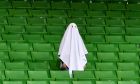 A man dressed as a ghost stands on the empty tribune prior the Europa League round of 16 first leg soccer match between Linzer ASK and Manchester United in Linz, Austria, Thursday, March 12, 2020. The match is being played in an empty stadium because of the coronavirus outbreak. (AP Photo/Kerstin Joensson)