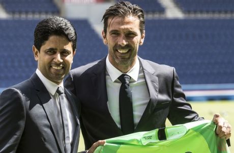 PSG's new signing goalkeeper Gianluigi Buffon, right, poses with Paris Saint-Germain's Qatari chairman and CEO Nasser Al-Khelaifi during his official presentation at the Parc des Princes stadium in Paris, France, Monday, July 9, 2018. Free agent Gianluigi Buffon signed for Paris Saint-Germain last Friday. The veteran goalkeeper penned a one-year deal at the French champion with the option for an additional season. (AP Photo/Jean-Francois Badias)