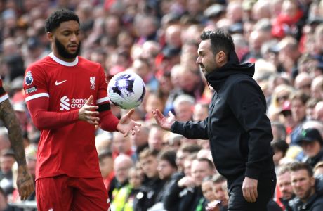 Brighton's head coach Roberto De Zerbi, right, gives the ball to Liverpool's Joe Gomez during the English Premier League soccer match between Liverpool and Brighton and Hove at Anfield Stadium in Liverpool, England, Sunday, March 31, 2024. (AP Photo/Rui Vieira)