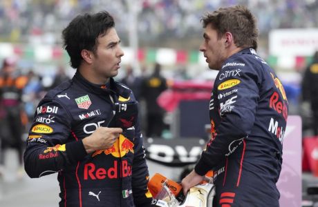Red Bull driver Max Verstappen of the Netherlands, right, and his teammates Sergio Perez of Mexico speak after the Japanese Formula One Grand Prix at the Suzuka Circuit in Suzuka, central Japan, Sunday, Oct. 9, 2022. (AP Photo/Eugene Hoshiko)