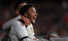 Manchester United's Jadon Sancho, left, is congratulated by teammates after scoring his team's third goal during a pre-season game between Manchester United and Crystal Palace at the Melbourne Cricket Ground in Melbourne, Australia, Tuesday, July 19, 2022. (AP Photo/Asanka Brendon Ratnayake)