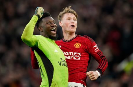 Manchester United's Scott McTominay, right, celebrates with Manchester United's goalkeeper Andre Onana at full time of the FA Cup quarterfinal soccer match between Manchester United and Liverpool at the Old Trafford stadium in Manchester, England, Sunday, March 17, 2024. Manchester United won 4-3. (AP Photo/Dave Thompson)