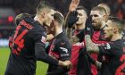 Leverkusen's Patrik Schick, left, celebrates with his teammates after he scored the first of his three goals during the German Bundesliga soccer match between Bayer Leverkusen and VfL Bochum at the BayArena in Leverkusen, Germany, Wednesday, Dec. 20, 2023. (AP Photo/Martin Meissner)