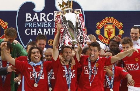 FILE - In this Sunday, May 11, 2008 file photo, Manchester United's, Ryan Giggs, center, lifts the trophy as his team celebrate winning the English Premier League after their 2-0 win against Wigan in their English Premier League soccer match at The JJB Stadium, Wigan, England. At left is Carlos Tevez and at right Cristiano Ronaldo. Manchester United great Ryan Giggs has ended his playing career after a club-record 963 appearances. Giggs made the announcement in an open letter on United's website on Monday, May 19, 2014,  the day he was hired as assistant manager to Louis van Gaal. (AP Photo/Jon Super, File) 