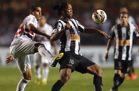 Ronaldinho of Brazil's Atletico Mineiro, right center, fights for the ball with Douglas of Brazil's Sao Paulo FC during a Copa Libertadores soccer match in Sao Paulo, Brazil, Thursday, May 2, 2013. (AP Photo/Andre Penner)
