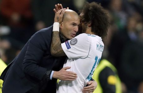 Real Madrid's Marcelo celebrates his side's 3rd goal with his head coach Zinedine Zidane during a Champions League Round of 16 first leg soccer match between Real Madrid and Paris Saint Germain at the Santiago Bernabeu stadium in Madrid, Spain, Wednesday, Feb. 14, 2018. (AP Photo/Francisco Seco)