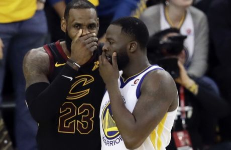 Cleveland Cavaliers forward LeBron James, left, talks with Golden State Warriors forward Draymond Green during the second half of Game 1 of basketball's NBA Finals in Oakland, Calif., Thursday, May 31, 2018. (AP Photo/Marcio Jose Sanchez)