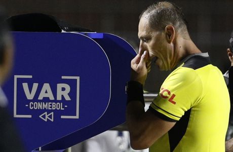 Referee Nestor Pitana looks at the VAR before awarding a penalty kick for Brazil during a Copa America Group A soccer match against Bolivia at the Morumbi stadium in Sao Paulo, Brazil, Friday, June 14, 2019. (AP Photo/Victor Caivano)